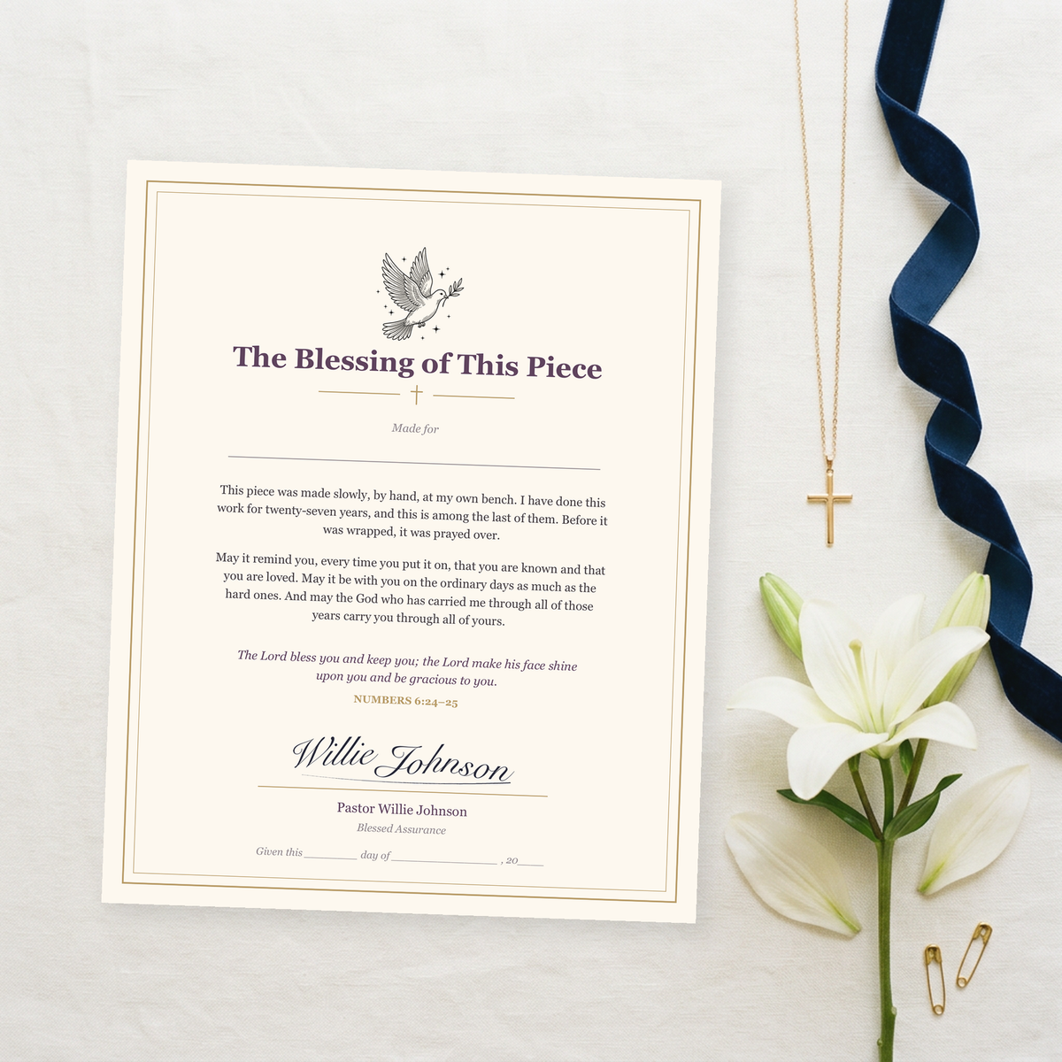A printable blessing from Pastor Willie, signed, beside a gold cross pendant and a white lily